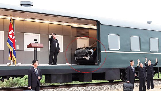 North Korean leader Kim Jong-un is seen waving from his private train during a visit to flood-affected areas in North Pyongan Province between Aug. 8 to Aug. 9 in 2024. A high-end Mercedes-Benz SUV, circled in red, is seen behind Kim inside the train. [YONHAP]