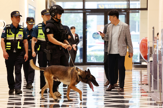 Police officials search for explosives following a bomb threat made against a department store in Gwangju on Aug. 11. [YONHAP]