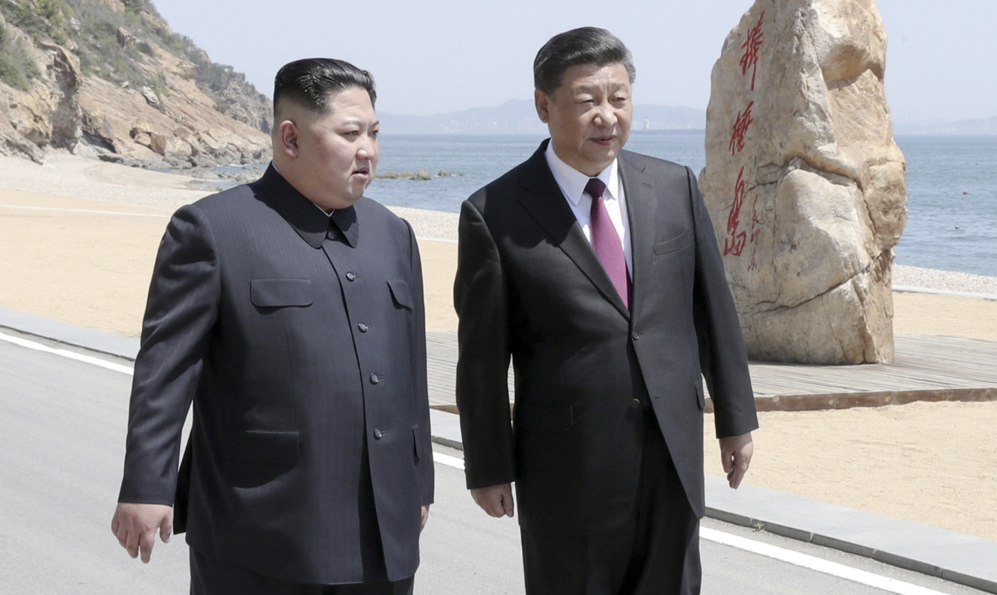 North Korean leader Kim Jong-un, left, walks alongside Chinese President Xi Jinping on a coastal road in Dalian during his second visit to China in early May 2018. [XINHUA/YONHAP]