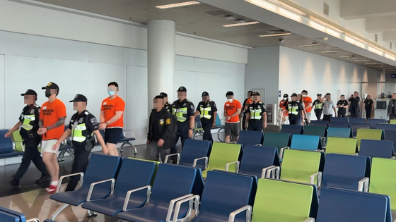 Local authorities escort a Korean fugitive at Ninoy Aquino International Airport in Manila, the Philippines, for repatriation to Korea on Sept. 3. [NATIONAL POLICE AGENCY]