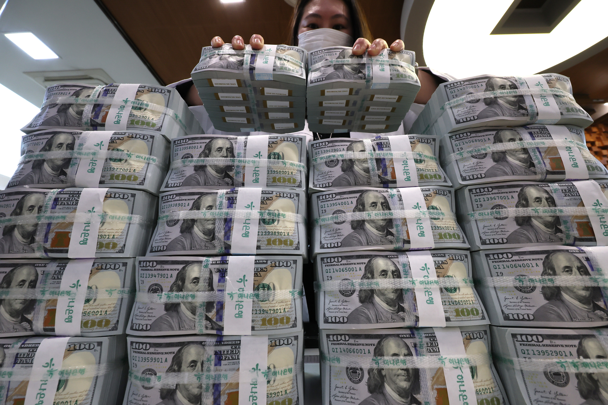 An official checks U.S. dollar notes at a bank branch of Hana Bank in central Seoul on March 31. [YONHAP]