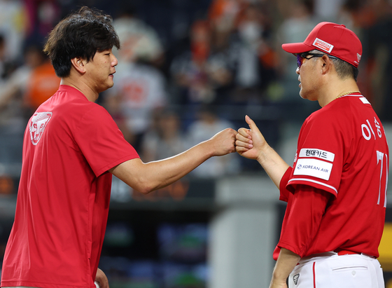 SSG Landers manager Lee Sung-yong, right, bumps fists with his pitcher Kim Kwang-hyun after a 9-3 win over the Hanwha Eagles in a KBO regular-season game at Daejeon Hanwha Life Ballpark in Daejeon, 140 kilometers south of Seoul, in this July 26 file photo. [YONHAP] 