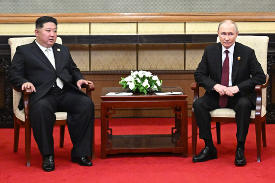 In this pool photograph distributed by the Russian state agency Sputnik, Russian President Vladimir Putin, right, and North Korean leader Kim Jong-un meet after attending a military parade marking the 80th anniversary of victory over Japan and the end of World War II, in Beijing, on Sept. 3. [AFP/YONHAP]