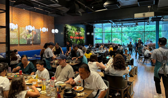 Customers eat fried chicken and other Korean food at a Genesis bbq store in the Philippines in this undated photo. [GENESIS BBQ]