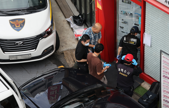 Police officers are at the scene of a fatal stabbing incident at a pizza franchise in Gwanak District, southern Seoul, on Sept. 3. [YONHAP] 
