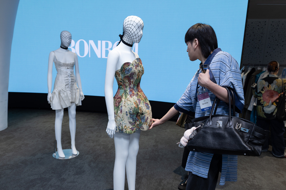 A buyer examines BonBom’s new Spring/Summer collection during a presentation at Seoul Fashion Week, held at Dongdaemun Design Plaza in Jung District, central Seoul, on Sept. 4. [SEOUL METROPOLITAN GOVERNMENT] 