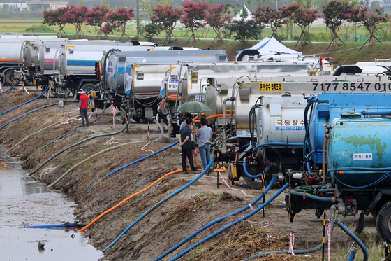 Water trucks line up to draw water from a stream in Gangneung, Gangwon, for transport as rain falls during the city’s worst drought on Sept. 7. [YONHAP] 