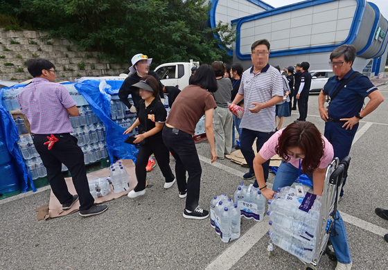 Residents receive bottled water at Gangnam Football Park in Gangneung, Gangwon, on Sept. 5. [YONHAP] 