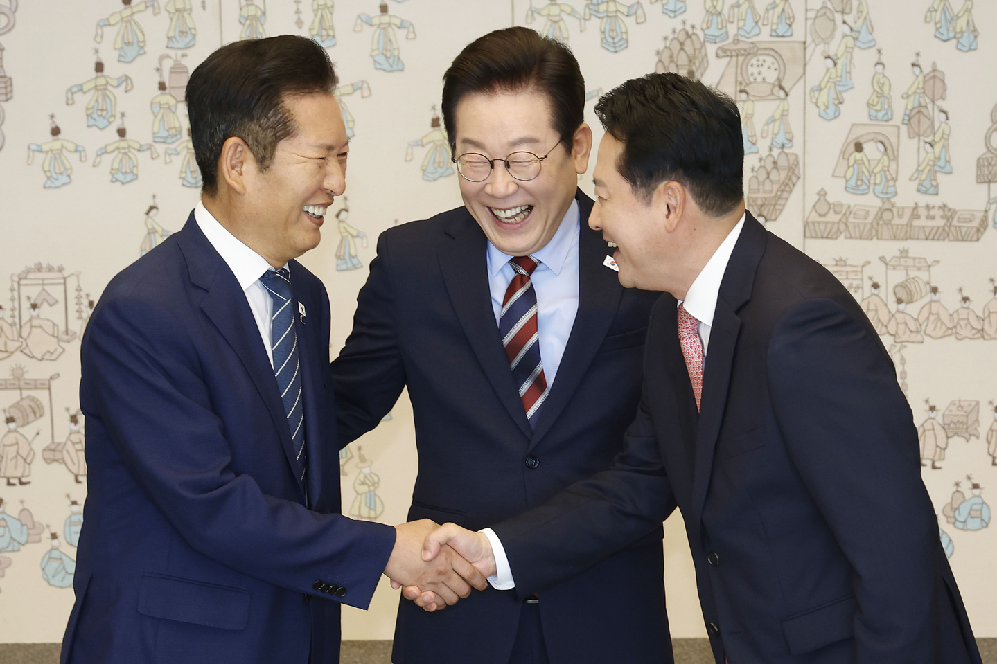 President Lee Jae Myung, center, looks on as Democratic Party leader Jung Chung-rae, left, and People Power Party leader Jang Dong-hyeok shake hands during a luncheon at the presidential office in Yongsan, central Seoul, on Sept. 8. [JOINT PRESS CORPS]