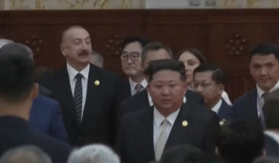 Woo Won-shik, speaker of the National Assembly, is seen behind North Korean leader Kim Jong-un at a reception in Beijing on Sept. 3, held to celebrate the 80th anniversary of the end of World War II. [YONHAP NEWS TV]