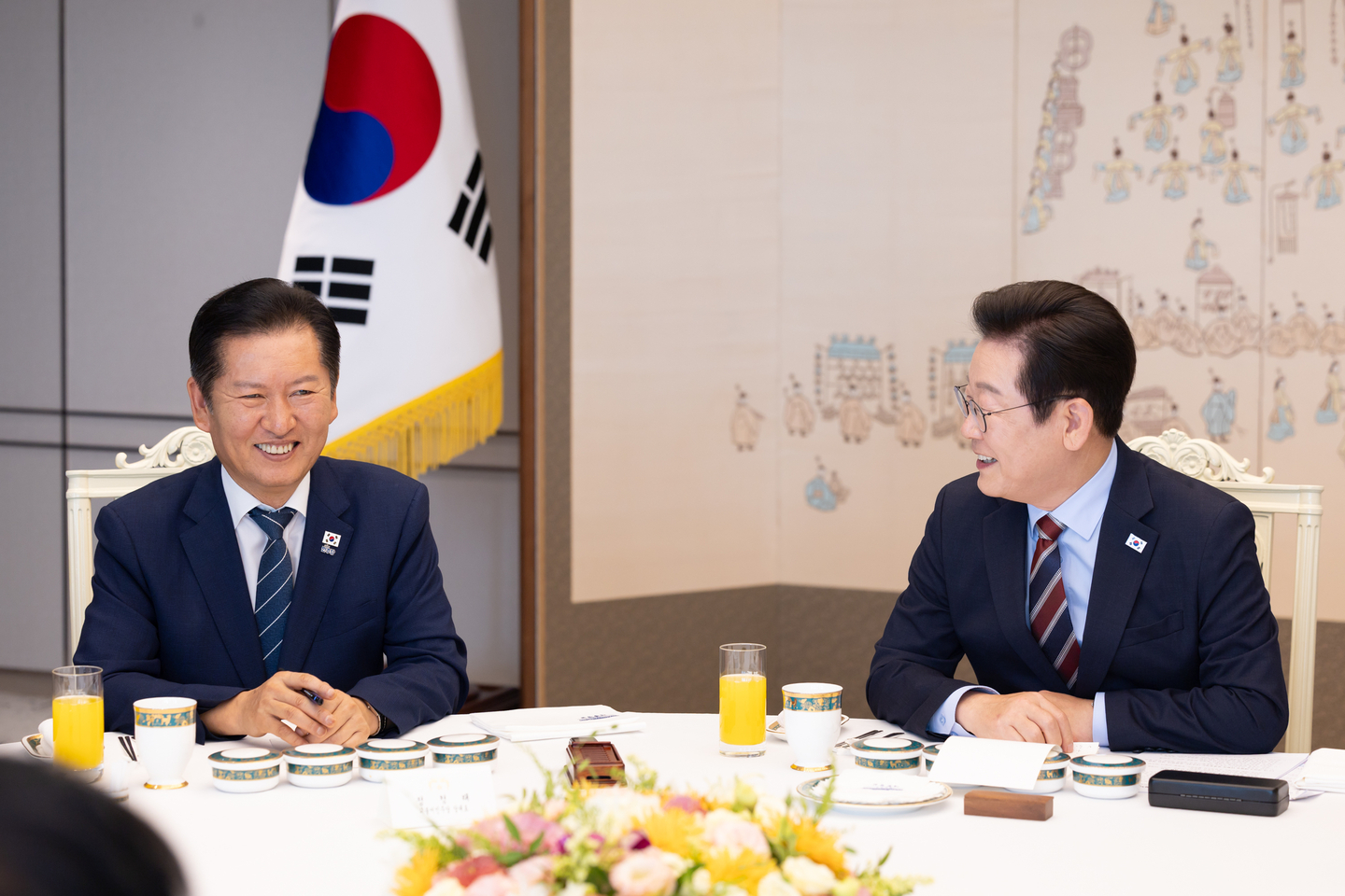 Democratic Party leader Jung Chung-rae, left, smiles at a luncheon with President Lee Jae Myung, right, and People Power Party leader Jang Dong-hyeok, not pictured in this photo, at the presidential office in Yongsan, central Seoul, on Sept. 8. [JOINT PRESS CORPS]