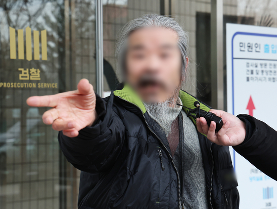 Cho Doo-soon, one of the nation's most notorious child rapists, answers reporters' questions at the Suwon District Court in Suwon, Gyeonggi, on March 11. 