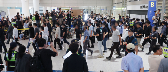 Korean workers who were detained by U.S. Immigration and Customs Enforcement in Georgia walk out of the arrivals hall at Terminal 2 of Incheon International Airport on Sept. 12. [JOINT PRESS CORPS]