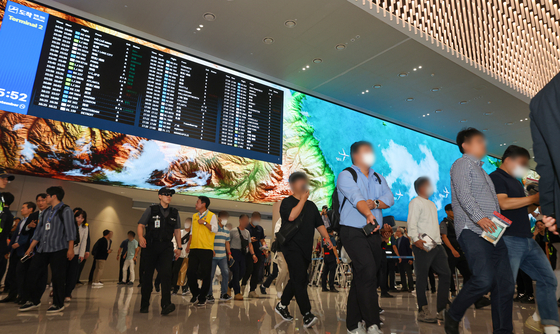 Korean workers who were detained by U.S. Immigration and Customs Enforcement authorities in Georgia walk out of the arrivals hall at Terminal 2 of Incheon International Airport on Sept. 12. [JOINT PRESS CORPS]