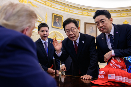 President Lee Jae Myung, second from right, and presidential chief of staff Kang Hoon-sik, far right, speak with U.S. President Donald Trump, far left, who is seated at the Resolute desk in the Oval Office of the White House in Washington on Aug. 25. [THE WHITE HOUSE]