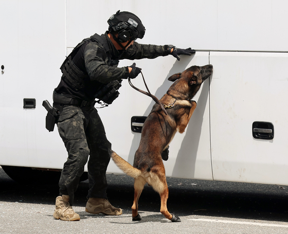 A police special forces officer take part in a bomb-search drill with a trained dog on Aug. 20. [YONHAP]