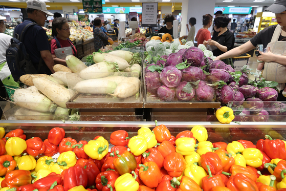 Customers pick out vegetables at a supermarket in Seoul on July 6. [YONHAP] 