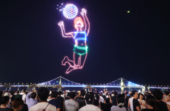 A drone light show themed around an international women's beach volleyball tournament takes place at Gwangalli Beach in Busan on Aug. 16. [YONHAP] 