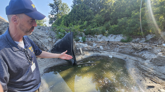 David Kennedy, a professor of medicine at the University of Toledo, points to a drainage outlet where pollutants from nearby farmland flow into the lake on Aug. 13 on the shore of Lake Erie’s western basin in Toledo, Ohio. [JEONG EUN-HYE] 