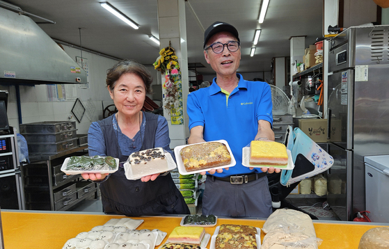 Jeong Jin-ki, head of the Guro Market merchants’ association, holds up rice cakes at Guro Market in Guro District, western Seoul, on Sept. 11. [KIM MIN-WOOK]