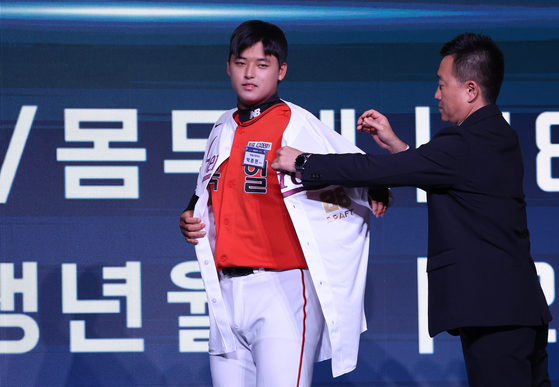 Park Jun-hyun, a right-handed pitcher from Bugil High School and the first overall pick in the first round, puts on his uniform after being selected by the Kiwoom Heroes during the 2026 KBO Rookie Draft at Lotte Hotel World in Songpa District, southern Seoul, on Sept. 17. [YONHAP]