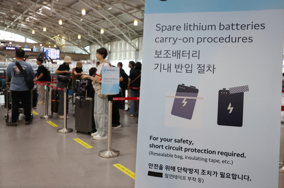 A notice explaining new procedures for carrying portable batteries on board is displayed in front of the check-in counters at Gimhae International Airport in Gangseo, Busan, on Sept. 1. [YONHAP] 