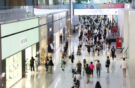 Travelers walk through the duty free zone of Terminal 2 at Incheon International Airport on Sept. 1. [YONHAP]
