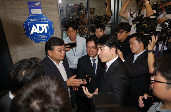 Special counsel Min Joong-ki’s team investigating allegations surrounding former first lady Kim Keon Hee speaks with a People Power Party lawyer before entering the party’s headquarters in Yeouido, western Seoul, for a raid related to the Unification Church's mass membership in the party on Sept. 18. [YONHAP]