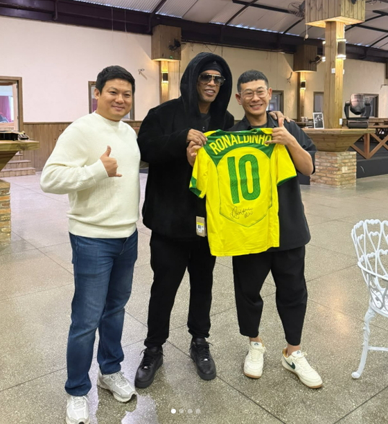 Lee Yoon-kyu, senior manager at Nexon, takes a photo with Ronaldinho when meeting him in Brazil to invite him to the Icons Match [SCREEN CAPTURE] 