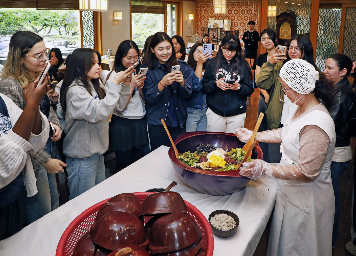 International visitors watch a cook explain how to make bibimbap at Jung Gang Won on Sept. 20, as part of Gangwon's Wellness Tour. [PARK SANG-MOON]