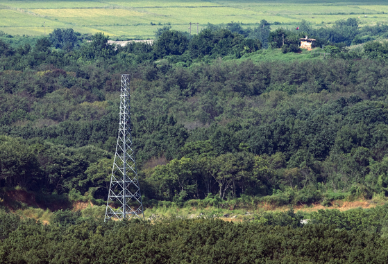 A transmission tower without power lines stands abandoned among the brush along the Gyeongui Line road in the demilitarized zone on the western front, as seen from Dora Observatory in Paju, Gyeonggi, on Sept. 3. [YONHAP]