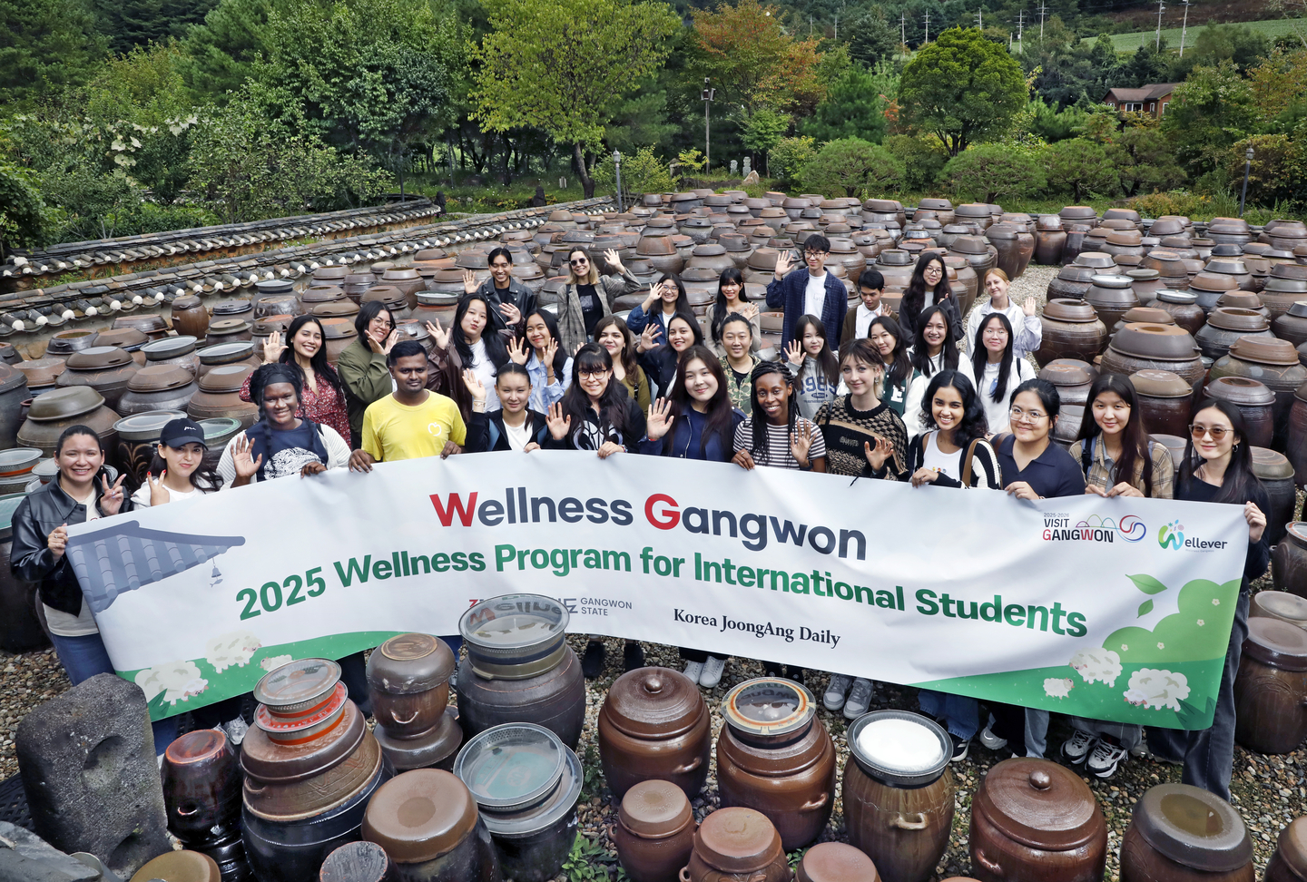 International visitors pose for a group photo against the backdrop of jangdokdae, large ceramic jars used to ferment kimchi, soy sauce and other condiments, at Jung Gang Won on Sept. 20 during Gangwon's Wellness Tour. [PARK SANG-MOON]