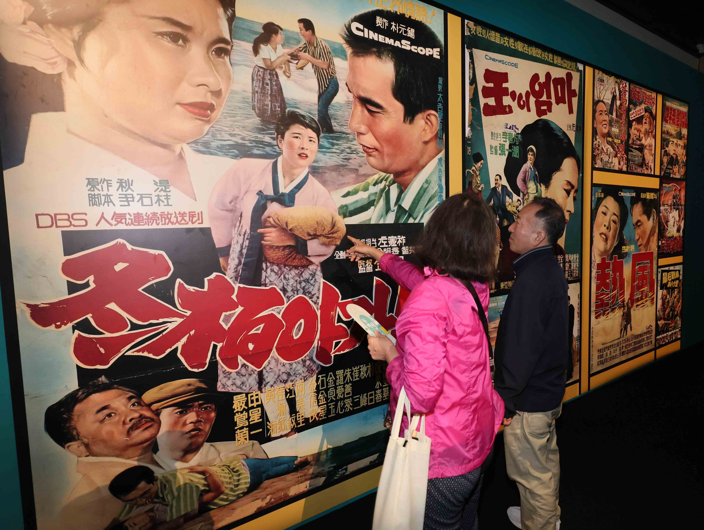Visitors view the cover of singer Lee Mi-ja’s 1964 hit “Dongbaek Agassi,” which translates to “Camellia Lady,” displayed at Busan Modern & Contemporary History Museum in Busan on Oct. 23, 2024. [SONG BONG-GEUN/JOONGANG PHOTO]