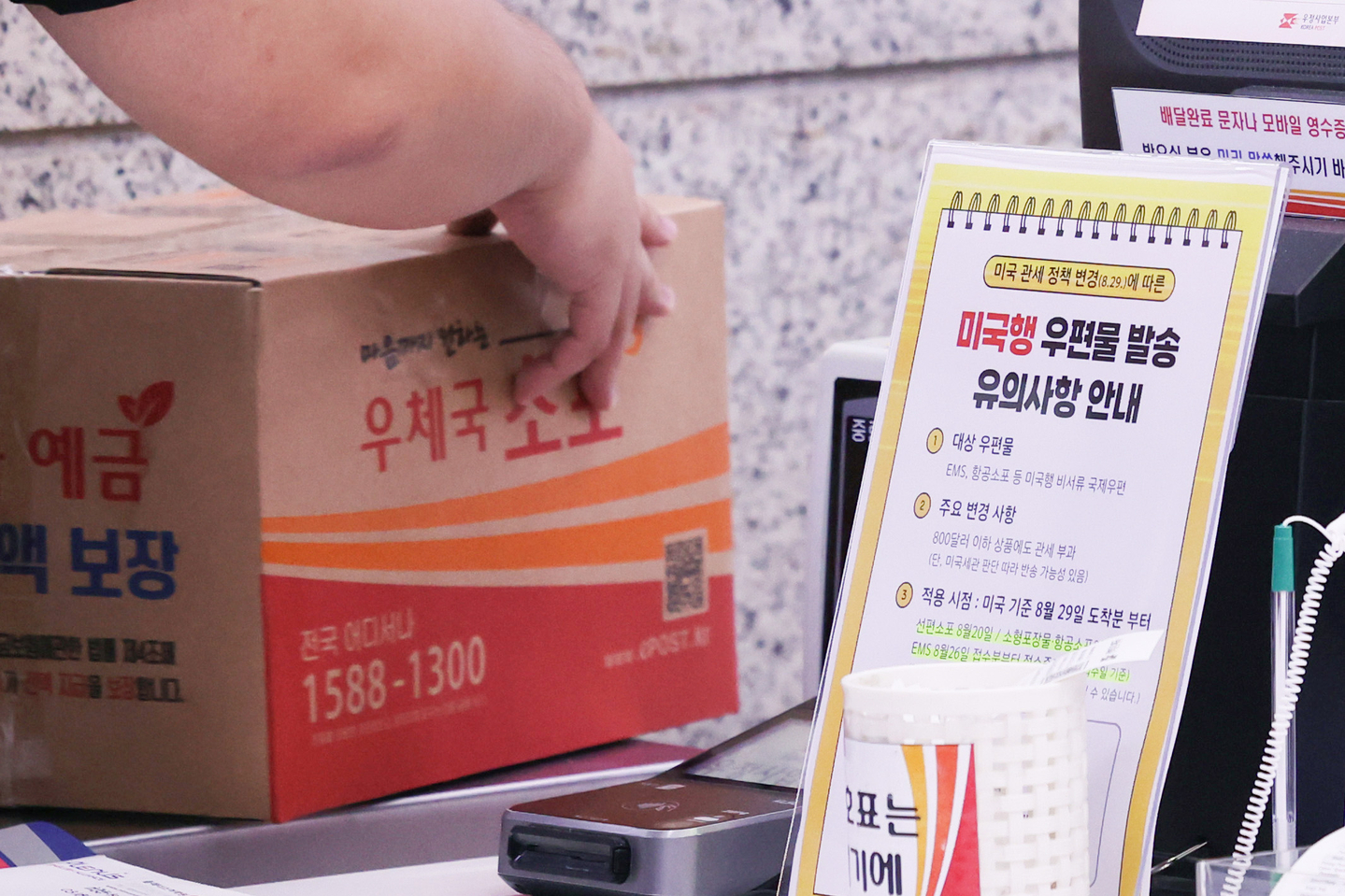 Customer weighs a parcel at the Post Office in Jongno District, central Seoul, on Aug. 25 [YONHAP]