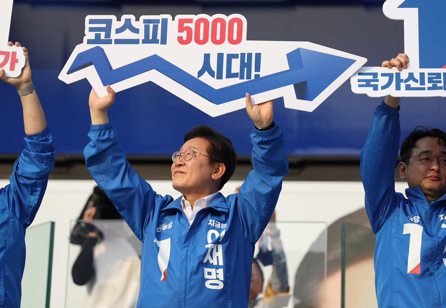 Lee Jae Myung, presidential candidate of the Democratic Party, holds a placard reading “Kospi 5000 Era” during an economic recovery performance at the Express Bus Terminal Plaza in Seocho District, southern Seoul, on May 29, the first day of early voting for the 21st presidential election. [YONHAP]