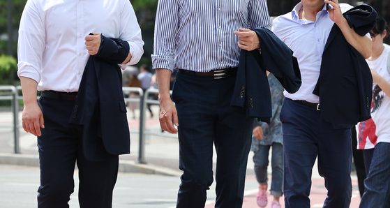 Corporate workers walk across a street in central Seoul on May 29, 2024. [YONHAP]