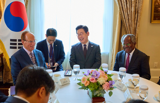 President Lee Jae Myung, center, speaks with BlackRock CEO Larry Fink, left, and Adebayo Ogunlesi, chairman of Global Infrastructure Partners, right, at a hotel in New York on Sept. 22. [JOINT PRESS CORPS]