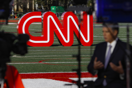 A journalist records video near a CNN sign on an athletic field outside the Clements Recreation Center where CNN and the New York Times hosted the Democratic presidential primary debate at Otterbein University in Westerville, Ohio, on Oct. 14, 2019i. Mark Thompson was appointed as chair and CEO of CNN by David Zaslav, head of the network's parent company, Warner Bros. Discovery, which made the announcement on Aug. 30, 2023. Thompson replaced Chris Licht, who was fired in June, and a four-person team that had been running CNN in the interim. [AP/YONHAP]