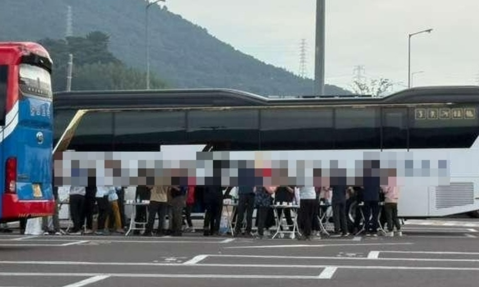 A group of tourists holds a drinking party in the parking area for large buses at Jinyeong Rest Area. [SCREEN CAPTURE}