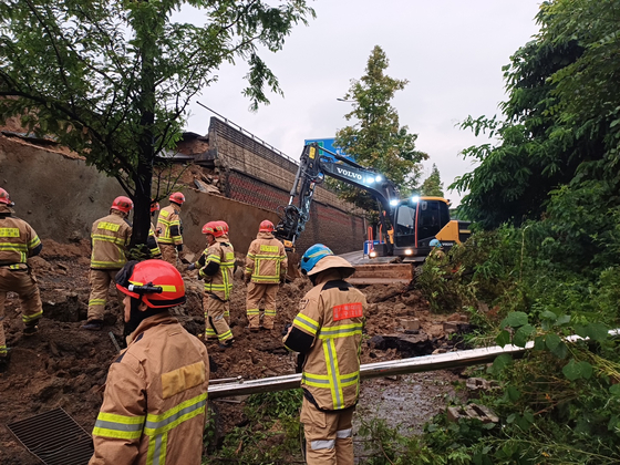 Firefighters respond after a retaining wall under an overpass collapsed and crushed a vehicle passing beneath at the Gajang Interchange in Osan, Gyeonggi, on July 16. [GYEONGGI FIRE AND DISASTER HEADQUARTERS]