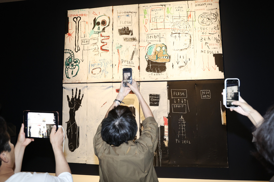 Visitors look around the exhibition hall during a press tour for a special exhibition of works by Jean-Michel Basquiat at Dongdaemun Design Plaza in Seoul on Sept. 22. [JEON MIN-KYU]