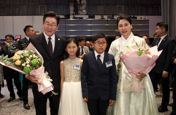 President Lee Jae Myung, left, and first lady Kim Hea Kyung, right, pose for a photo with children at a dinner event for the Korean community in New York on Sept. 22. [JOINT PRESS CORPS] 