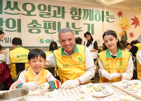 S-Oil CEO Anwar A. Al-Hejazi prepares songpyeon (moon-shaped rice cake) gift packages to give out as part of the Chuseok celebrations with company staff at the company headquarters in Gongdeok-dong, western Seoul. [S-OIL]