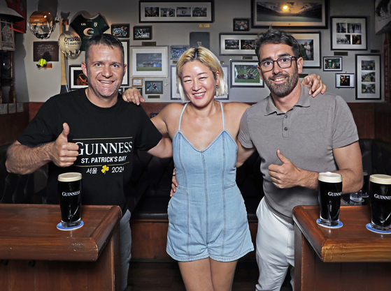 The Craic House co-owners who go by Timmo, left, and Soyeon, center, along with Kevin Conlan at the pub in Yongsan District, central Seoul [PARK SANG-MOON]