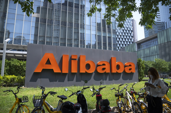 A pedestrian walks past the offices of Chinese technology firm Alibaba in Beijing on Aug. 10, 2021. Chinese regulators will exercise greater control over the algorithms used by Chinese technology firms to personalize and recommend content, in the latest move in a regulation spree across the internet sector. The planned regulations could affect companies like ByteDance and Alibaba, which use algorithms to offer personalized services to users. [AP/YONHAP]