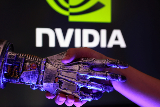 A person shakes hands with a 3-D-printed robot's hand in front of the Nvidia logo in this illustration from Aug. 27. [REUTERS/YONHAP]