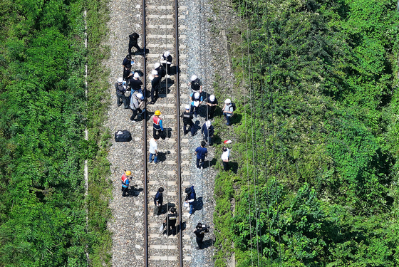 Police officers examine a site near the tracks of the Seoul-Busan railway in Cheongdo, North Gyeongsang, southeastern South Korea, on Aug. 19, after a Mugunghwa train hit seven workers inspecting structures on a slope near the tracks. [YONHAP]