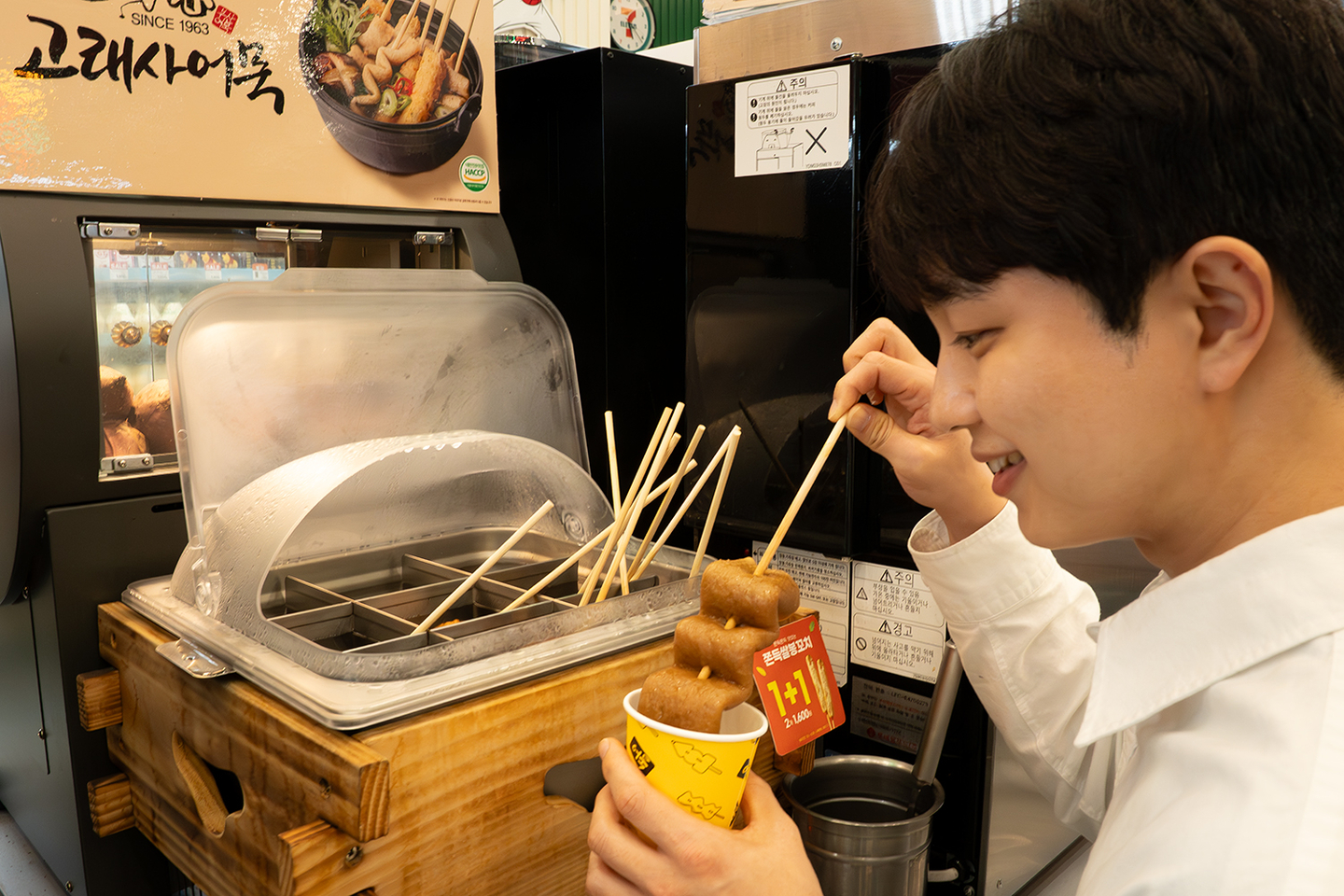 Convenience store chain 7-Eleven began selling popular winter snacks such as roasted sweet potatoes, five types of eomuk (fish cakes) and three kinds of bungeoppang (fish-shaped pastries) starting Sept. 22. A customer selects roasted sweet potatoes at a store. [7-ELEVEN]