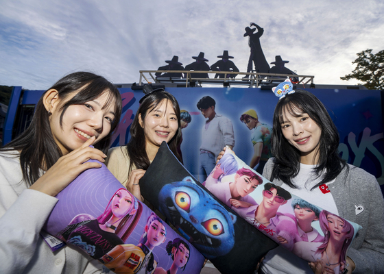 People hold "KPop Demon Hunters" merchandise set to be available at Everland. [EVERLAND]