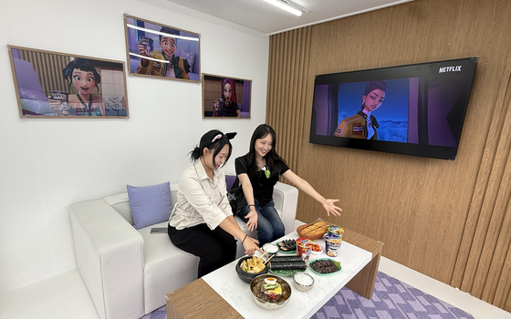 In the HUNTR/X zone, the film’s opening airplane scene, where the girl group members stuff themselves with foods like gimbap (seaweed rice roll) and ramyeon before a concert, is recreated. [WOO JI-WON]